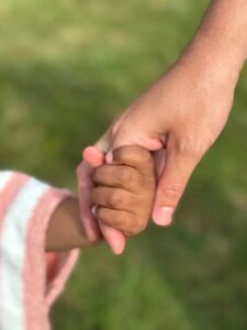 heartfelt moment of holding hands outdoors