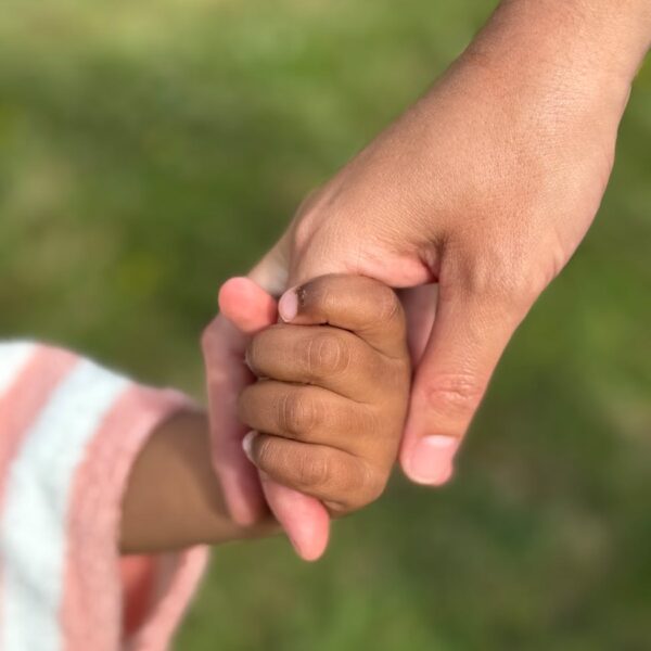 heartfelt moment of holding hands outdoors