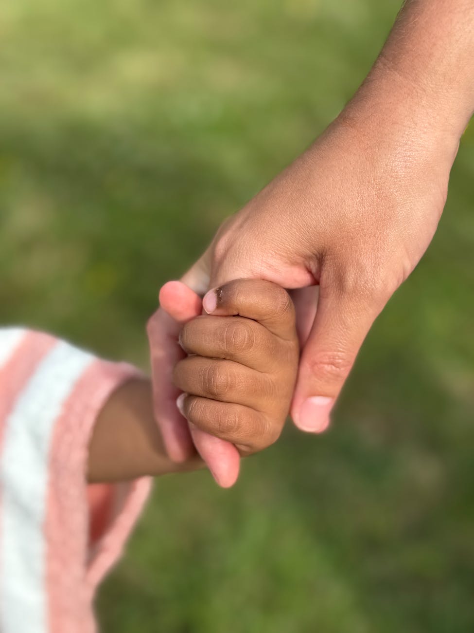 heartfelt moment of holding hands outdoors